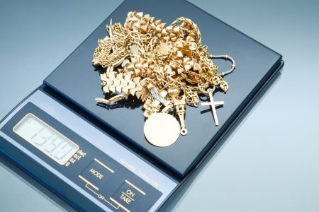 Weighing gold to determine the weight and ultimately the price for selling jewelry